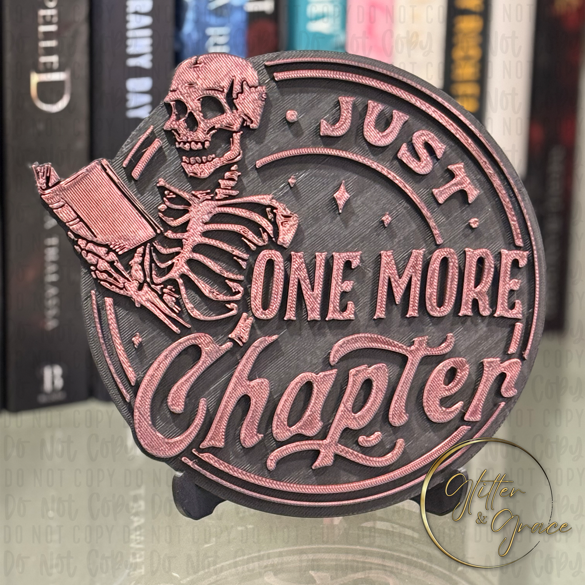 3d printed books shelf sign with the image of a skeleton reading a book saying one more chapter