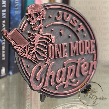 3d printed books shelf sign with the image of a skeleton reading a book saying one more chapter