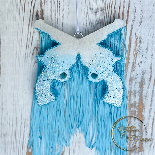 dual revolver shaped vehicle air freshener decorated with white and light blue glitter and light blue fringe