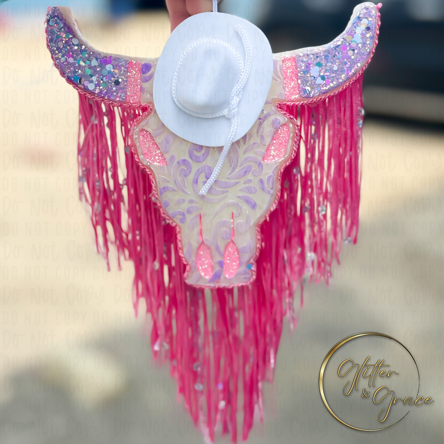 vehicle air freshener shaped as a bull decorated with lace cowboy hat and fringe